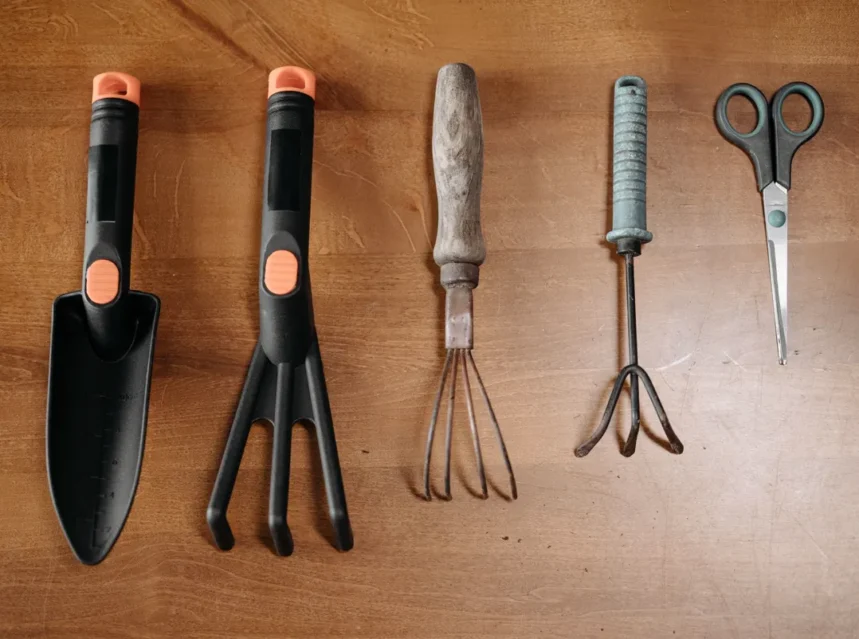 Best garden tool set — five hand tools laid in a row on wood - trowel, three-prong fork, two cultivators and scissors