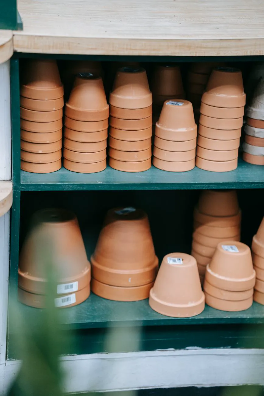 Rows of terracotta plant pots on garden centre shelves