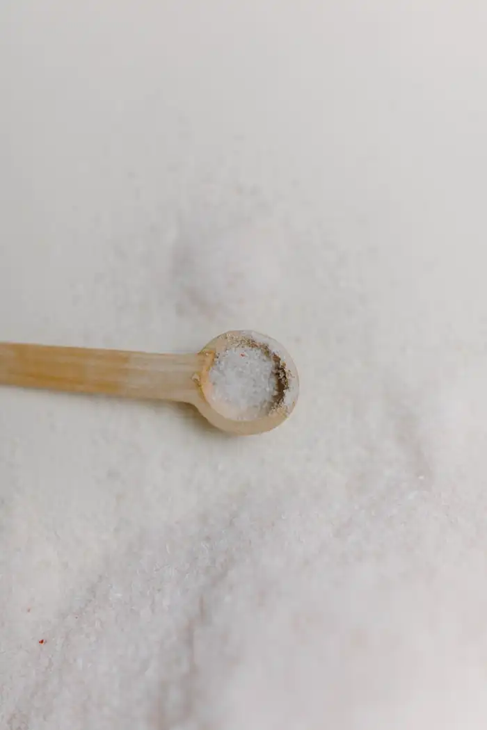 Measuring a small spoon of fine white salt.