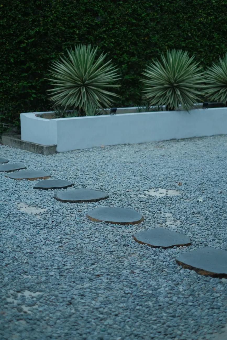 Low Maintenance Landscaping Ideas — Circular stone pathway in a modern garden with agave.