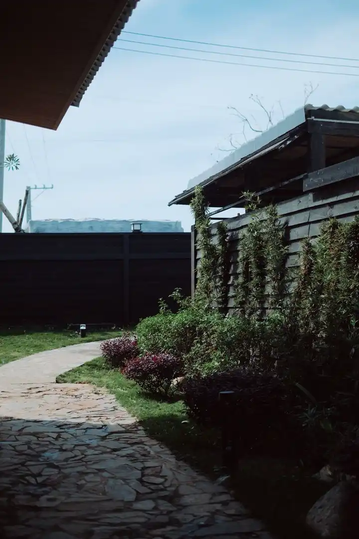 Curved flagstone path through a small garden with lawn and shrubs