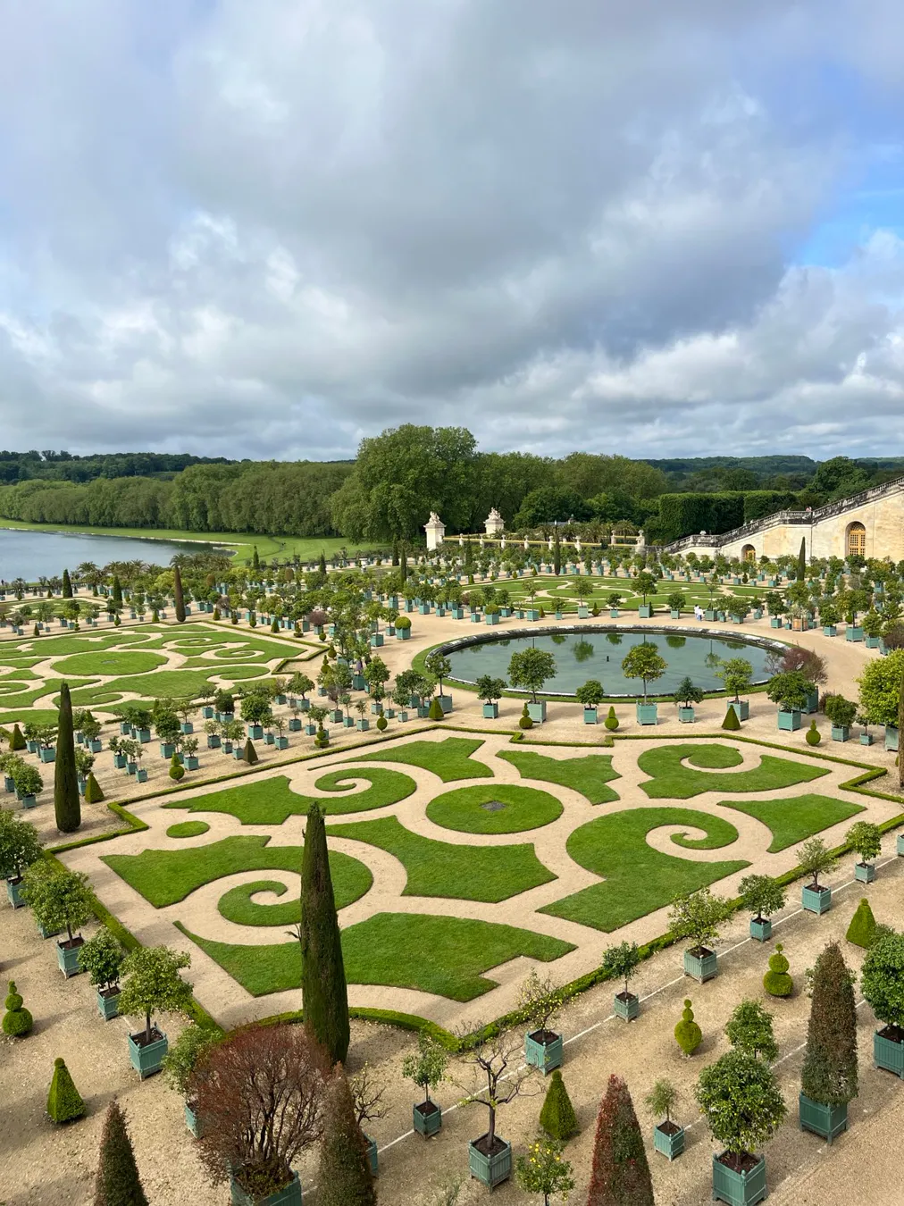 Clipped grass scrollwork parterre at the Orangerie, with rows of trees in square tubs on gravel